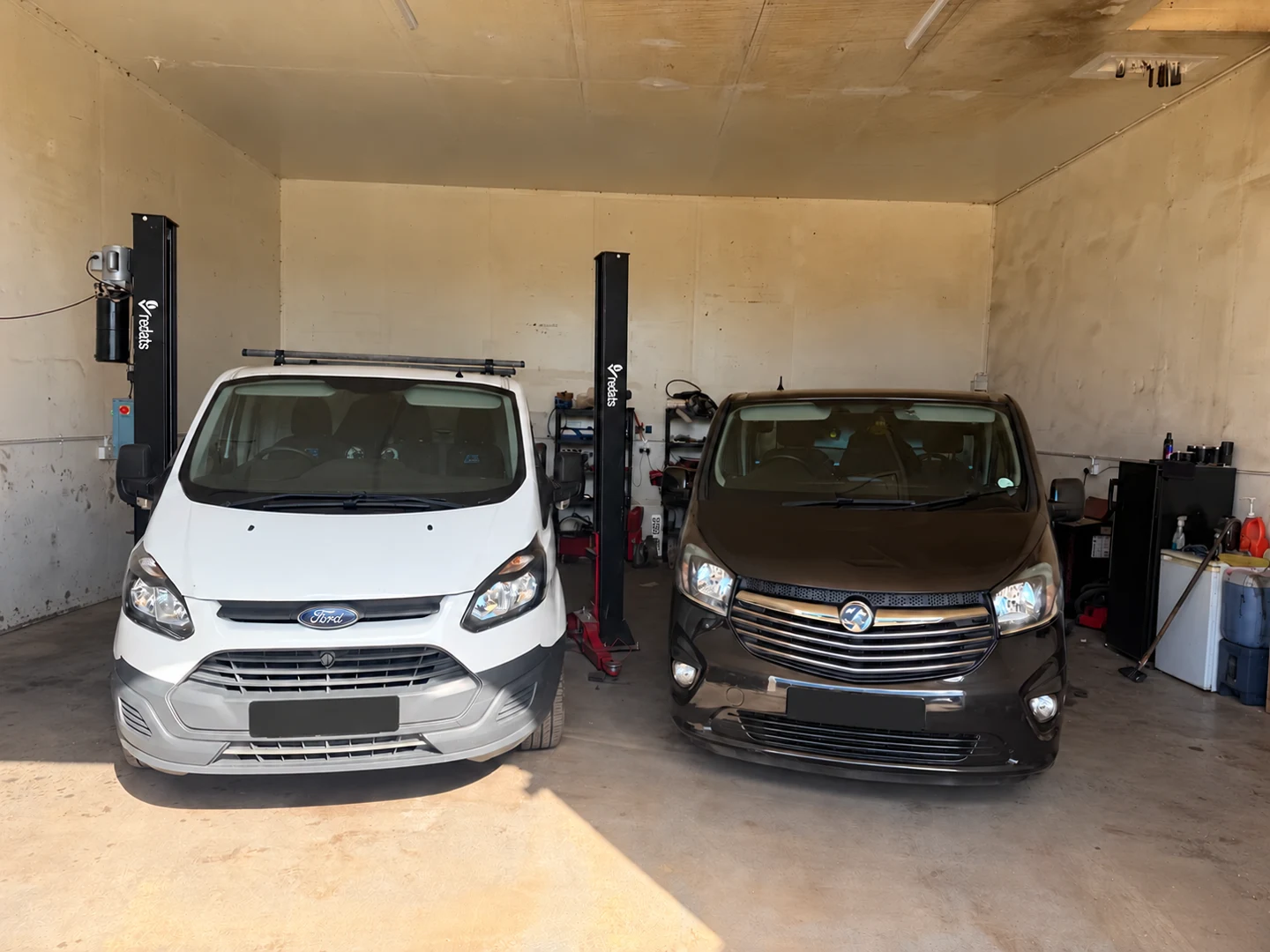 Ford and Vauxhall vans in the Pearls workshop, with number plates covered