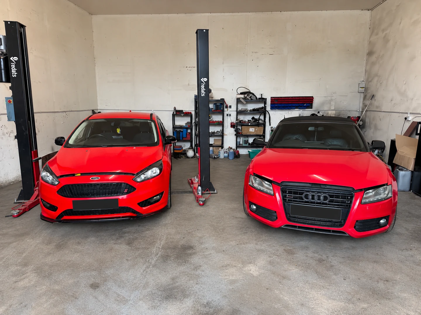Red Ford and Audi in the Pearls workshop for general repairs and wetbelt work, with number plates covered
